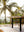 Outdoor dining set on a white rug with tropical backdrop